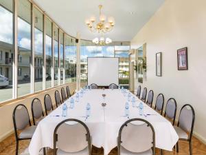 a conference room with a long table with chairs and a whiteboard at BreakFree Queanbeyan in Queanbeyan +32 photos