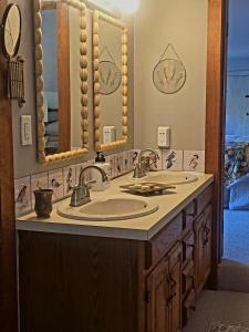 un baño con dos lavabos y dos espejos en The Cardinal Lodge- A Riverside Retreat, en Newfane
