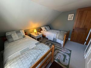 Un pequeño dormitorio con dos camas y una mesa. en The Cardinal Lodge- A Riverside Retreat, en Newfane