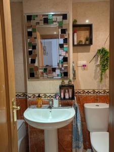 a bathroom with a sink and a toilet and a mirror at Oropesa summer in Oropesa del Mar