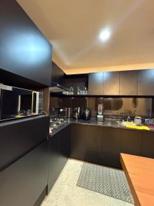 a kitchen with black cabinets and a microwave at Estancia pino suarez in Xalapa +56 photos