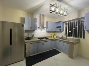 a kitchen with blue cabinets and a stainless steel refrigerator at Jeda Village in Higuey