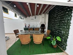 a dining room with a table and chairs and a wall at Refúgio das Alfazemas in Vila Nova de Milfontes