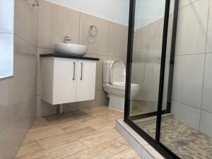 a bathroom with a sink and a toilet at The Manzi Villa in Hartbeespoort