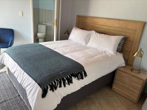 a bedroom with a bed with a blue blanket on it at The Manzi Villa in Hartbeespoort