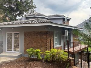 a house with a porch and a balcony at The Manzi Villa in Hartbeespoort