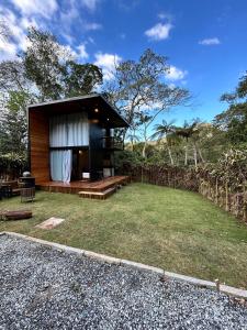 a small house with a grassy yard in front at Chalé Industrial Pedra do Imperador in Nova Friburgo