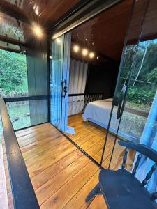 a room with a bed and a room with glass doors at Chalé Industrial Pedra do Imperador in Nova Friburgo +45 photos