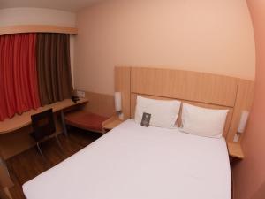 Una habitación de hotel con una cama y una ventana roja. en ibis Contagem Ceasa, en Contagem
