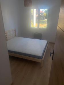 a small bed in a room with a window at Magnifique maison neuve Mimizan plage proche océan in Mimizan-Plage +14 photos