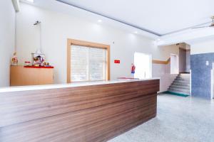a bar in the middle of a room with stairs at Capital O Crosswind Gold in Indirapuram