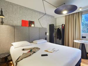 a hotel room with a bed with a white bedspread at Ibis Sallanches Porte du MontBlanc in Sallanches