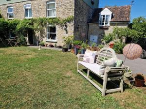a chair sitting in the grass in front of a house at Worth House in Wookey