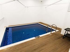 a swimming pool in a room with a wooden floor at Mercure Baku City in Baku