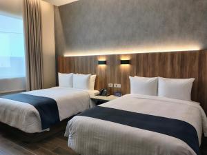 a hotel room with two beds and a window at Hotel Soretti in Durango