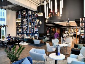 Un vestíbulo de una tienda con sillas y mesas. en ibis Styles Saint Nazaire Centre Gare, en Saint-Nazaire