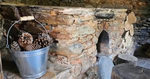 un secchio di pigne in un muro di pietra di Linhares - Country House Turismo, Natureza e Aventura a Castanheira de Pêra