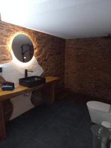 un bagno con lavandino, WC e specchio di Linhares - Country House Turismo, Natureza e Aventura a Castanheira de Pêra