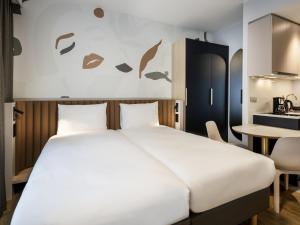 a bedroom with a bed and a table at Adagio access Brussels Delta in Brussels