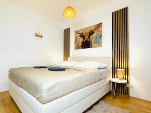 une chambre avec un lit avec un tableau sur le mur dans l'établissement Katys Cozy Corner - Self CheckIn, à Graz 15 autres photos