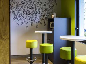 a room with two tables and two stools at Ibis budget Lorient Caudan in Caudan