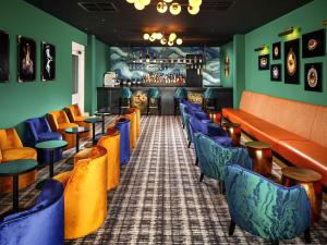 a bar with orange and blue chairs in a restaurant at Mercure Brighton Seafront Hotel in Brighton & Hove