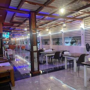 a dining room with tables and chairs and lights at AK Guesthouse in Maputo