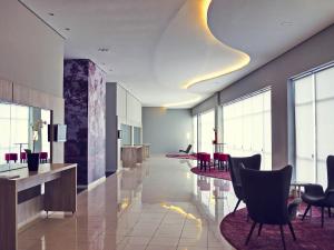a lobby with chairs and tables in a building at Mercure Sao Jose dos Campos in São José dos Campos