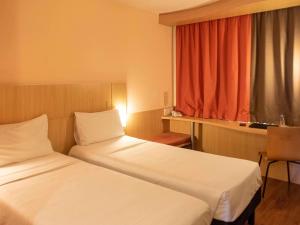 a hotel room with two beds and a window at ibis Sao Paulo Barra Funda in Sao Paulo