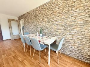 a dining room with a table and chairs and a brick wall at FeWo W6 in Fürstenau