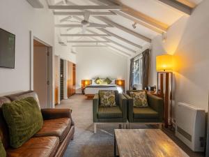 a hotel room with a bed and a couch and a table at Peppers Cradle Mountain Lodge in Cradle Mountain