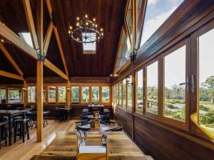 a dining room with tables and chairs and windows at Peppers Cradle Mountain Lodge in Cradle Mountain