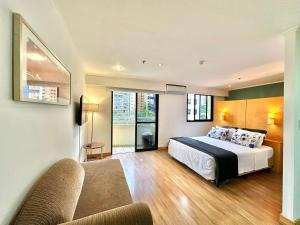 a hotel room with a bed and a couch at Flat Itaim Bibi ar condicionado arrumação diária in Sao Paulo