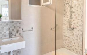 a bathroom with a glass shower with a sink at 1 Bedroom Amazing Apartment In Omis in Omiš