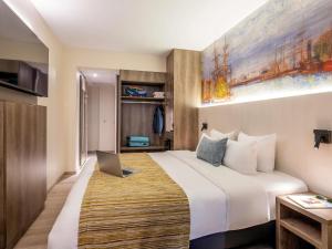 a hotel room with a bed with a laptop on it at Mercure Oostende in Ostend