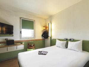 a bedroom with a large white bed and a window at ibis budget Hamburg City in Hamburg