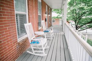 three rocking chairs on a porch of a house at Victorian Gem Steps from Main St - Sleeps 9 & Pets in St. Charles