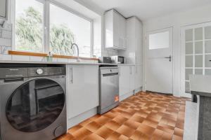 a kitchen with a washer and dryer in it at Modern 3Bed Escape - Work&Relax - Free Parking in Chigwell