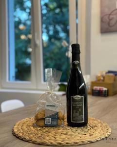 a bottle of wine and a basket of bread on a table at La Filanda Apartment in Castelvetro di Modena