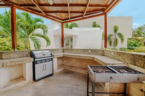 an outdoor kitchen with a grill and a stove at Exclusiva casa en Baru con piscina y playa privada in Playa Blanca