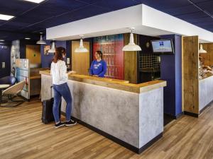 two women standing at a counter in a restaurant at ibis budget Southampton Centre in Southampton