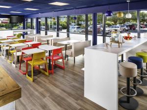 a restaurant with tables and chairs and windows at ibis budget Southampton Centre in Southampton