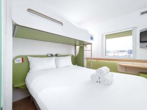 a hotel room with a large bed with towels on it at ibis budget Southampton Centre in Southampton