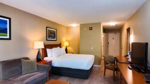 a hotel room with a bed and a desk at Ramada by Wyndham Kelowna Hotel & Conference Center in Kelowna