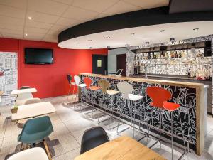 a bar with a bunch of chairs and a counter at ibis Rennes Cesson in Cesson-Sévigné