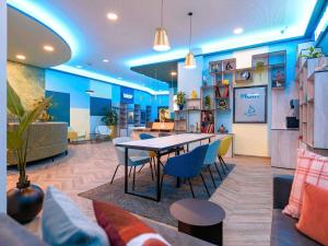 a room with a table and chairs and a couch at Aparthotel Adagio Access Kiel City in Kiel