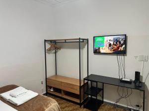 a bedroom with a bed and a tv on a wall at Casa aconchegante Barroca in Belo Horizonte