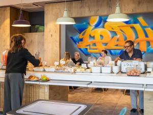 a group of people sitting at a table eating food at ibis Lyon Part Dieu Les Halles in Lyon