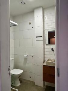 a white bathroom with a toilet and a sink at Alvaro Guest House in Rio de Janeiro