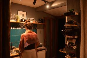 a woman standing in a kitchen in a room at Casinha do Fotógrafo em Domingos Martins a 7km do Centro in Domingos Martins